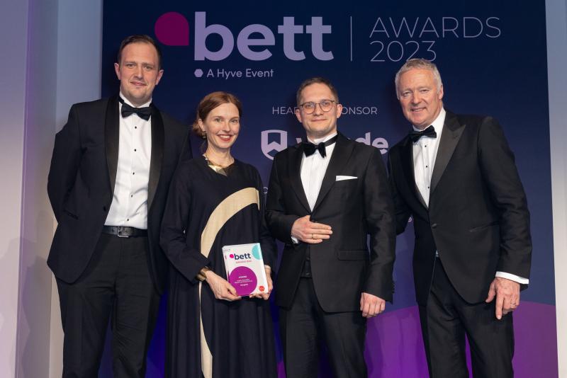 Four people posing with an award 