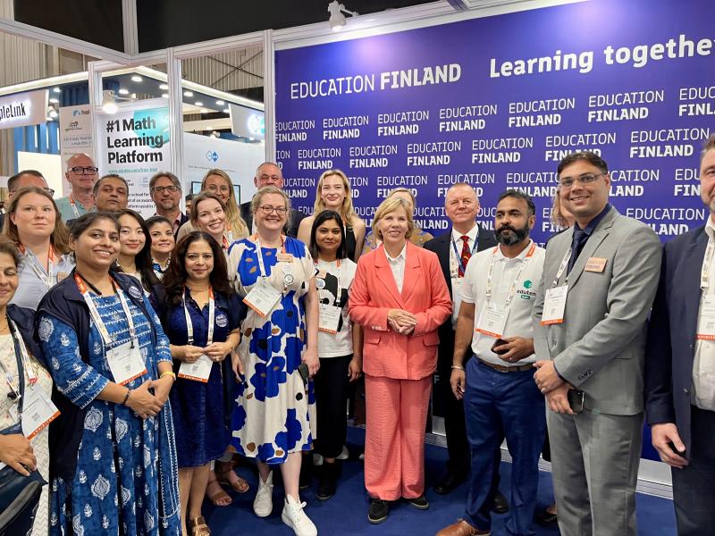 A large group of people posing for the camera in the Finland Pavilion at the Didac exhibition